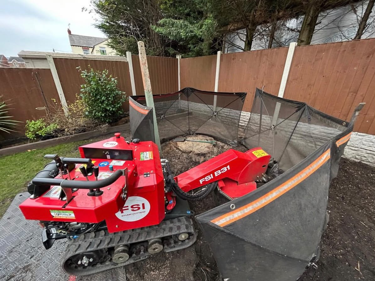 FSI B31 tracked stump grinder with safety screens set up around a stump in a fenced garden